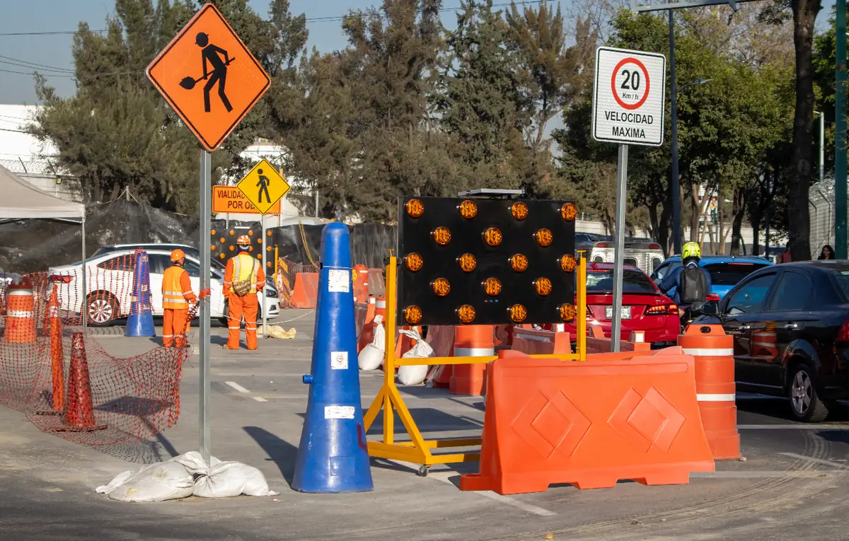 Barrera Ray naranja sin reflejantes cerrando un carril en una obra vial de la Ciudad de México, junto a conos, trafitambos y un tablero de flechas